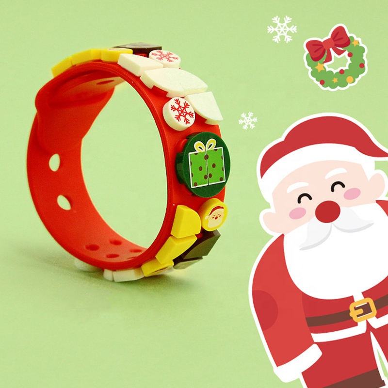 Beside the curled red Children's Building Vlock Bracelet on a green background stands Santa Claus