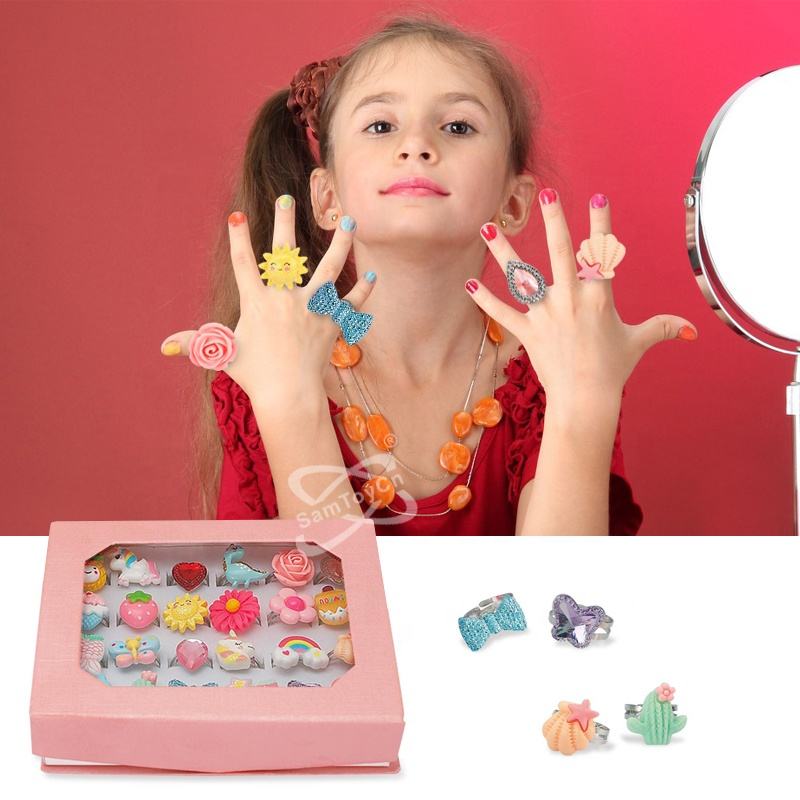 A little girl in a red dress holds out all ten fingers to show off her Ring Toy