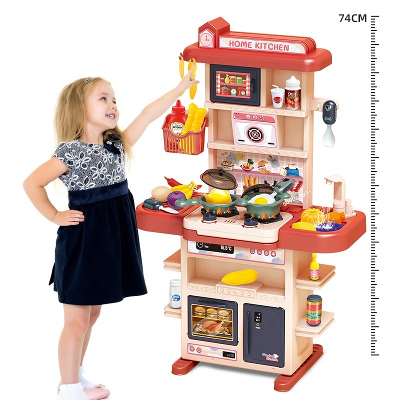 A little blonde girl stood beside the pink Tableware Table, pointing at the toy she wanted to play with