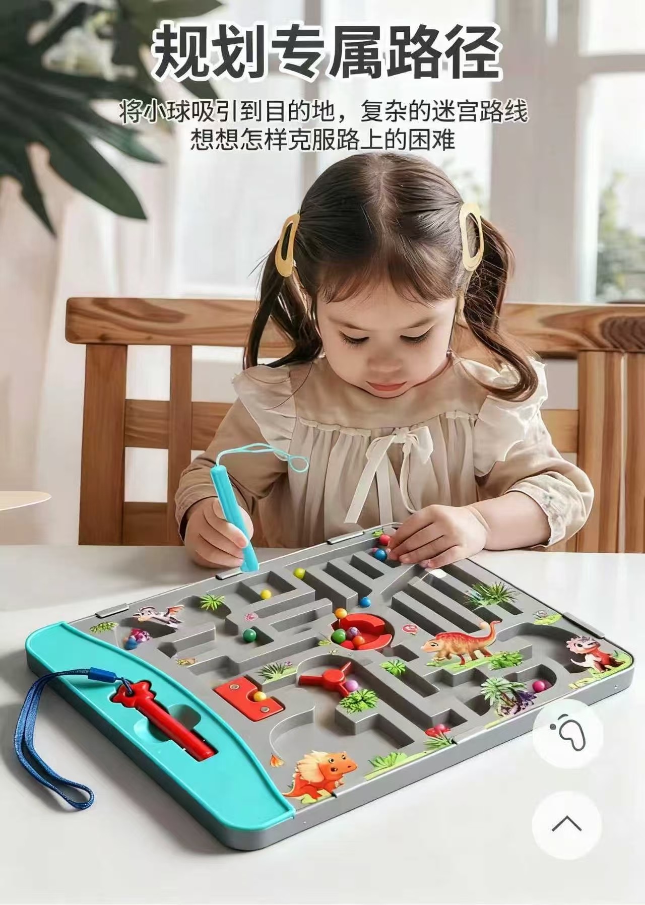 The little girl holds the magnetic pen, guiding the ball through the Dinosaur Magnetic Maze Land toys to its destination